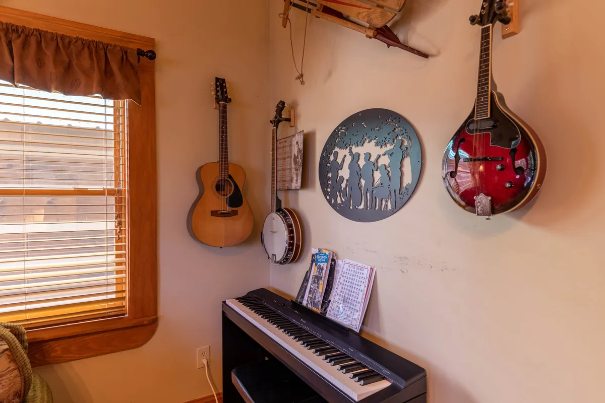 A close-up view of a music corner with acoustic guitar, banjo, mandolin, and piano, complemented by music-themed wall art. These instruments and art create an unmistakably musical atmosphere.